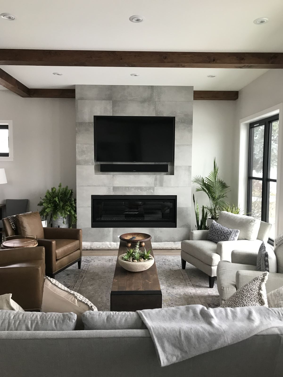 Living room with TV mounted above a tiled fireplace