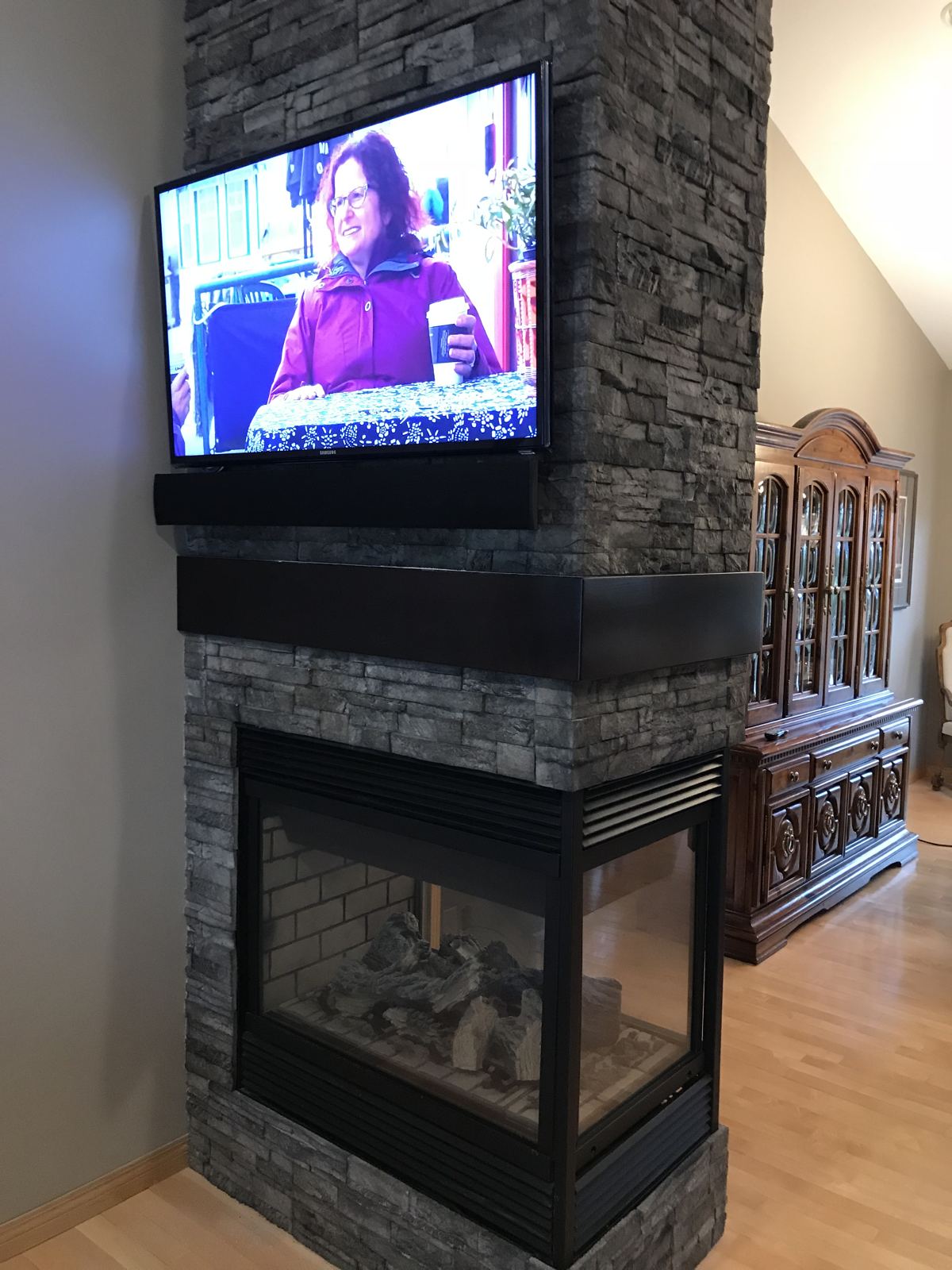TV mounted above a stone fireplace